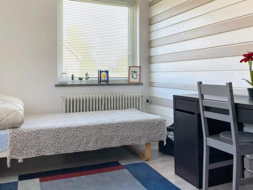 Zimmer mit einem Bett, einem Schreibtisch und einem Fenster in der Unterkunft Holiday home Sibbhult II in Sibbhult