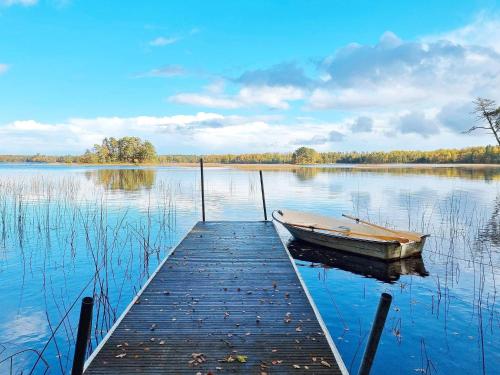 a boat is docked at a dock on a lake at 5 person holiday home in Sibbhult-By Traum in Sibbhult