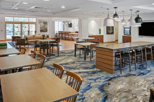 a cafeteria with tables and chairs and a couch at Fairfield Inn & Suites Rancho Cordova in Rancho Cordova