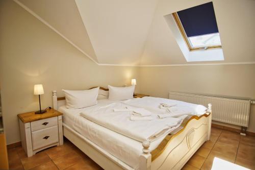 um quarto com uma cama branca e uma janela em Ferienwohnung mit traumhaftem Meerblick - Haus am Meer FeWo 12 em Lohme