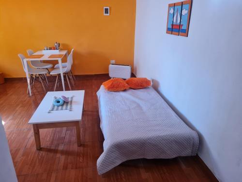 Habitación pequeña con cama y mesa en Departamento privado cerca del Aeropuerto en Ezeiza