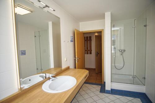 W łazience znajduje się umywalka i prysznic. w obiekcie Ferienwohnung mit traumhaftem Meerblick - Haus am Meer FeWo 01 w mieście Lohme