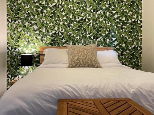 1 cama en un dormitorio con una pared verde en The Finch Beach Resort en North Bay