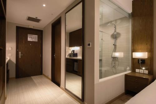 a bathroom with a walk in shower and a glass door at Panorama Apartment Nha Trang in Nha Trang