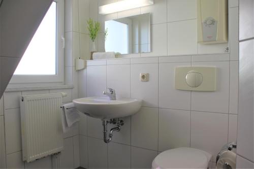 a white bathroom with a sink and a toilet at Roter Erik App 4, DG re in Kirchdorf