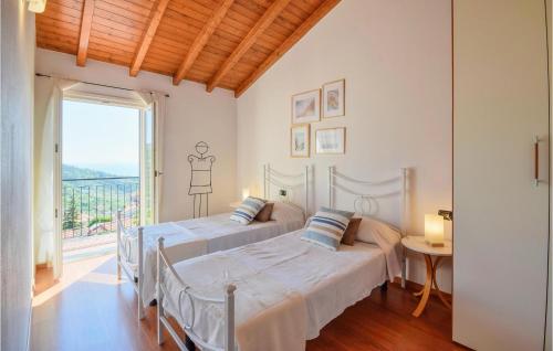 - 2 lits dans une chambre avec une grande fenêtre dans l'établissement 2 Bedroom Nice Home In Moneglia, à Moneglia