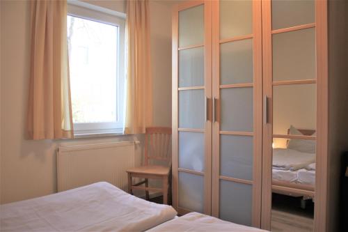 a bedroom with a sliding glass door with a bed at Roter Erik App 2, EG li in Kirchdorf