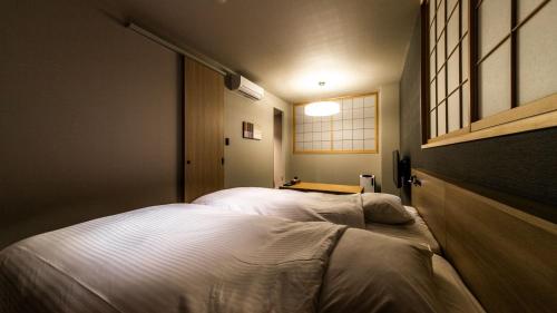 Postel nebo postele na pokoji v ubytování ALPHABED INN Fukuoka Ohori Park