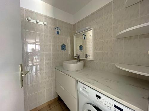 y baño con lavabo y lavadora. en Appartement Saintes-Maries-de-la-Mer, 3 pièces, 6 personnes - FR-1-475-29, en Saintes-Maries-de-la-Mer