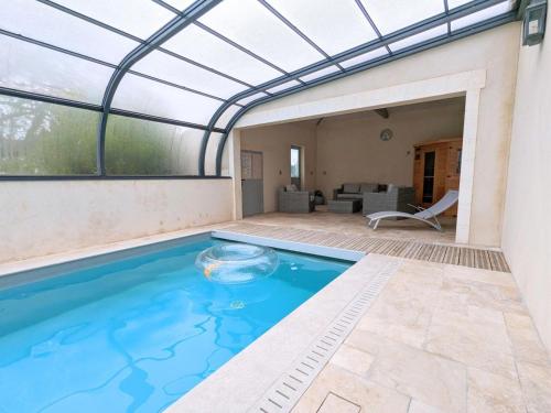 une piscine intérieure avec un plafond en verre et une terrasse dans l'établissement Maison Charentaise Rénovée: 3 Ch, Terrasse, Piscine Chauffée, Sauna, Jardin, Équipements Bébé, WiFi - FR-1-653-80, à Salles-de-Barbezieux