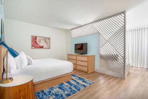 a bedroom with a white bed and a tv at Margaritaville Vacation Club - Nashville in Nashville