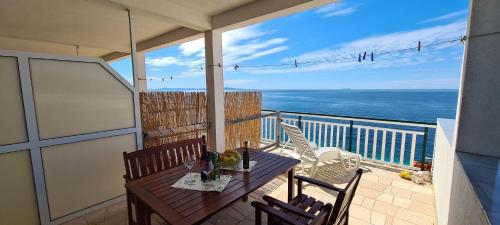 a balcony with a table and chairs and the ocean at Apartments Ana i Ante Punta in Milna