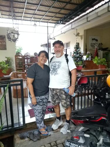 a man and a woman standing next to a scooter at Pujihouse One in Legian
