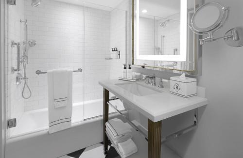 a bathroom with a sink and a shower and a mirror at InterContinental New York Barclay Hotel by IHG in New York