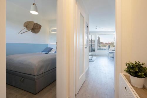 a bedroom with a bed and a room with a hallway at Sol Mare 25 Ostseezeit in Kellenhusen