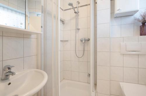 a white bathroom with a shower and a sink at Sol Mare 25 Ostseezeit in Kellenhusen