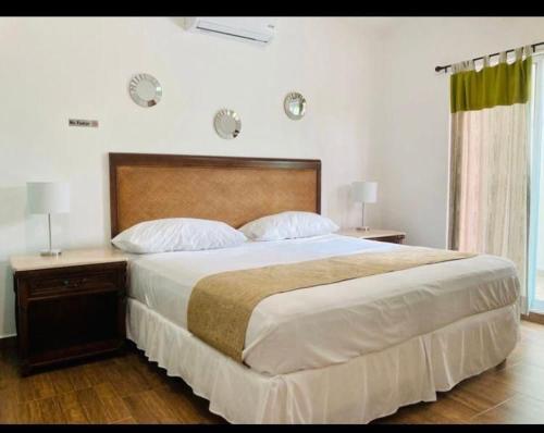 1 dormitorio con 1 cama grande, 2 mesitas de noche y 2 lámparas en Homecancun en Cancún