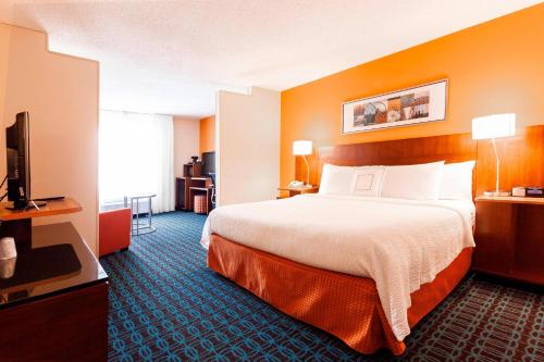 ein Hotelzimmer mit einem Bett und einem Flachbild-TV in der Unterkunft Fairfield Inn by Marriott Ponca City in Ponca City