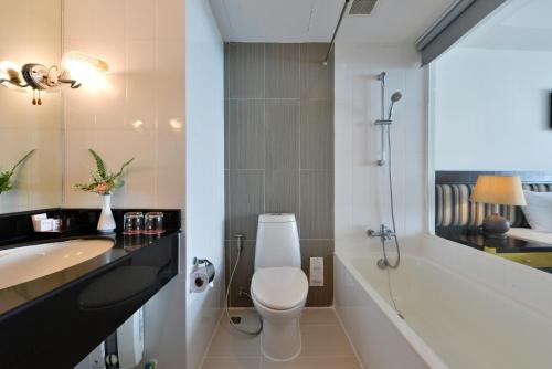a bathroom with a toilet and a sink and a tub at D Varee Jomtien Beach, Pattaya in Jomtien Beach