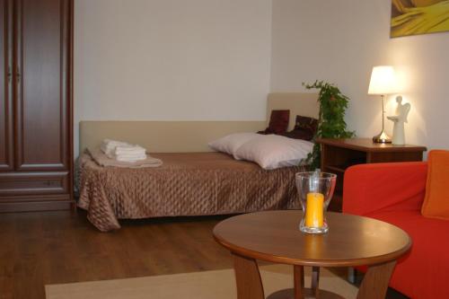 キェルツェにあるApartament Parkowyのベッド1台、テーブル(ガラス付)が備わる客室です。