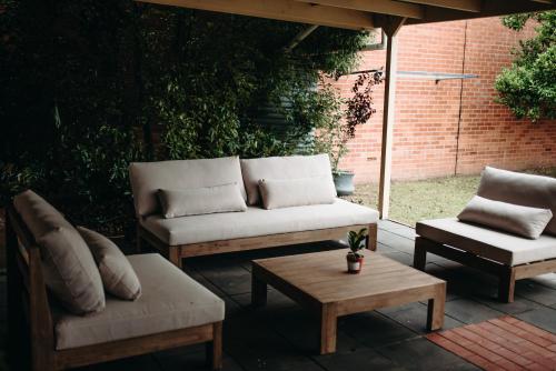 un patio con 2 sofás y una mesa de centro en The Pioneer - A Luxurious, Federation Home. en Dubbo
