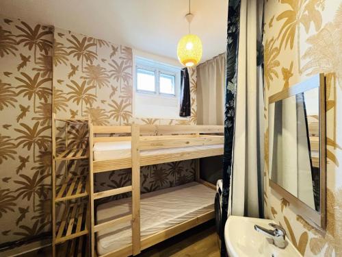 Cette chambre comprend des lits superposés, un lavabo et un miroir. dans l'établissement Le Mont-Dore - Agréable T2 bis avec wifi - FR-1-608-246, à Le Mont-Dore