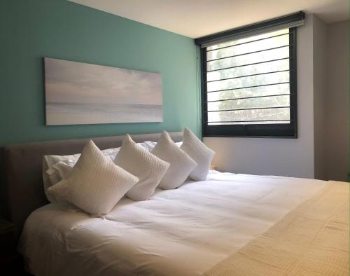 a bedroom with a bed with white pillows and a window at Pegado a la Condesa gran ubicación King size in Mexico City