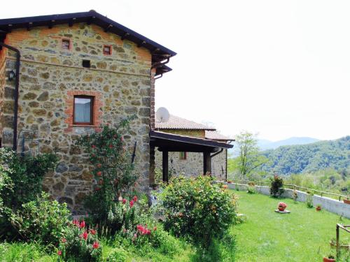 a stone house with a garden in front of it at Holiday Home in Tuscany with Natural Pond in Gavedo