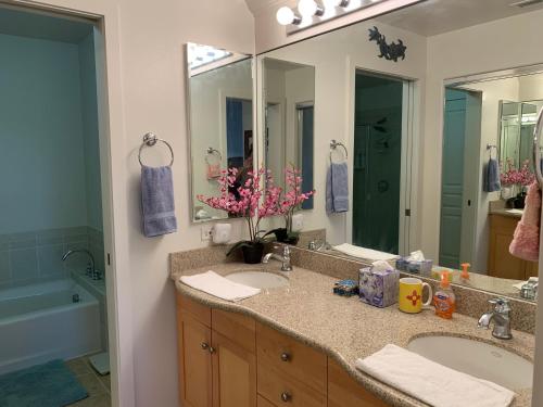a bathroom with two sinks and a large mirror at Ko Olina Ocean View Home Office in Kapolei