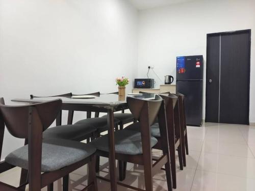 a kitchen with a table with chairs and a refrigerator at Sakura homestay 5 bedrooms - Spring Lopeng 14 pax in Miri