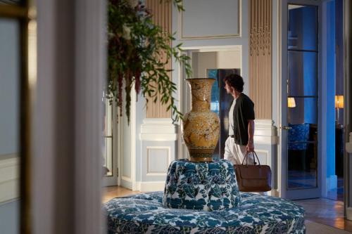 a man standing in a room with a vase on a table at Santo Mauro, a Luxury Collection Hotel, Madrid in Madrid