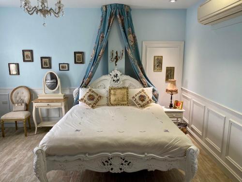 a bedroom with a white bed with a canopy at 法國小古堡-Chateau de France in Wujie