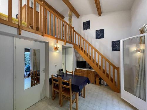 une salle à manger avec une table bleue et un escalier dans l'établissement Villa calme à Agde, proche plage, avec terrasse ombragée et parking privé - FR-1-723-101, au Cap d'Agde