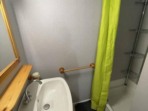 La salle de bains est pourvue de toilettes et d'un rideau de douche vert. dans l'établissement Villa calme à Agde, proche plage, avec terrasse ombragée et parking privé - FR-1-723-101, au Cap d'Agde