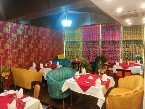 a restaurant with tables and chairs and red and pink wallpaper at Hotel Crystal Rose - Sylhet in Sylhet