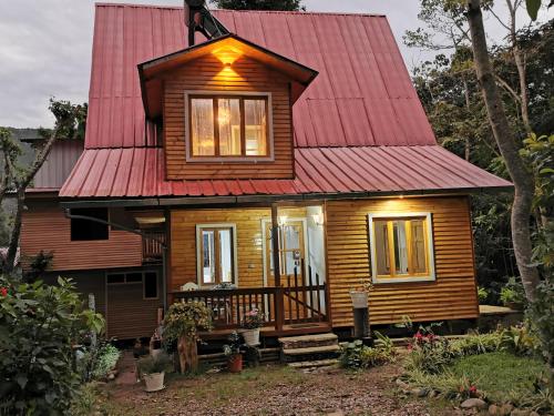 una pequeña casa de madera con techo rojo en La casa del Erizo en Oxapampa