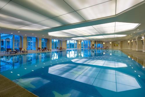 a swimming pool in a hotel with a large ceiling at Crowne Plaza Ocean Spring Resort by IHG in Jimo