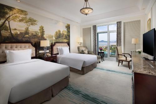 a hotel room with two beds and a television at Crowne Plaza Ocean Spring Resort by IHG in Jimo
