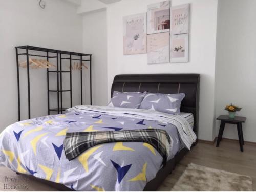 una camera con letto e piumone viola e giallo di [FREE WI-FI]Travelers Homestay Sitiawan[6~10Pax]The Venus Apartment a Sitiawan