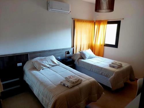 una camera d'albergo con due letti e una finestra di Casa - del TALAMPAYA a Villa Unión