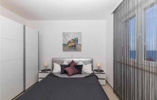 Amazing Apartment In Okrug Gornji With Kitchen في تروغير: غرفة نوم مع سرير مع مواقف ليلتين