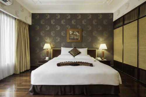 a bedroom with a large white bed in a room at Rex Hotel in Ho Chi Minh City