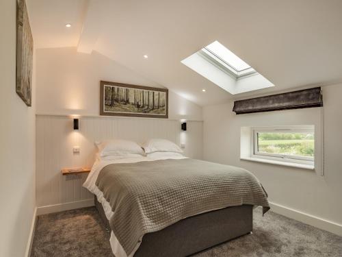 a bedroom with a bed and a skylight at The Old Haybarn in Longford