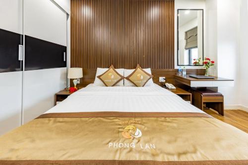 a bedroom with a large bed and a desk at Phong Lan Apartments in Hai Phong
