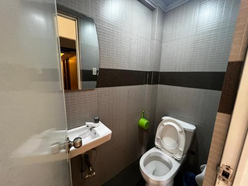 uma pequena casa de banho com WC e lavatório em Stone House Manila em Manilla