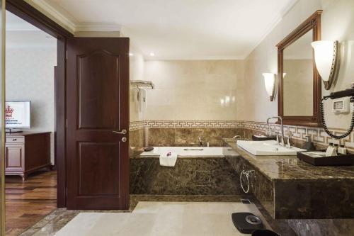 a bathroom with two sinks and a large mirror at Rex Hotel in Ho Chi Minh City