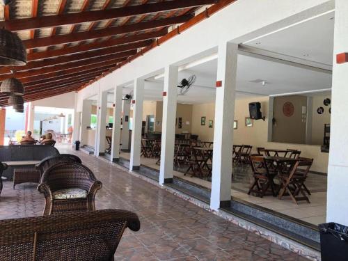 a patio with tables and chairs and a bunch of chairs at Acqua Ville Flats II - Caldas Novas Center in Caldas Novas