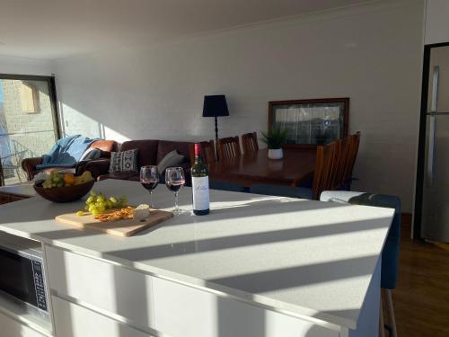 a kitchen with a table with two glasses of wine at Jindabyne Lake View in Jindabyne