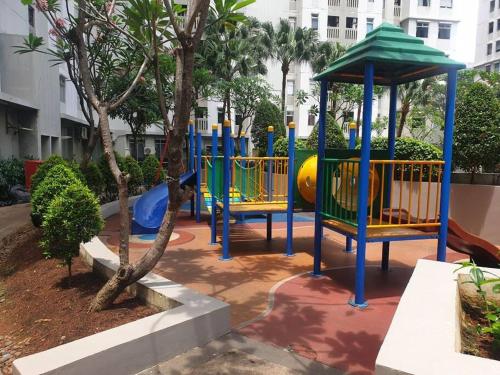park z placem zabaw ze zjeżdżalnią i drzewami w obiekcie Apartemen 1 BR Studio Baywalk Pluit Cozy Aesthetic North Jakarta w Dżakarcie
