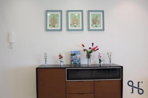a cabinet with a vase of flowers on top of it at Homesuite' Home at The Loft in Kota Kinabalu